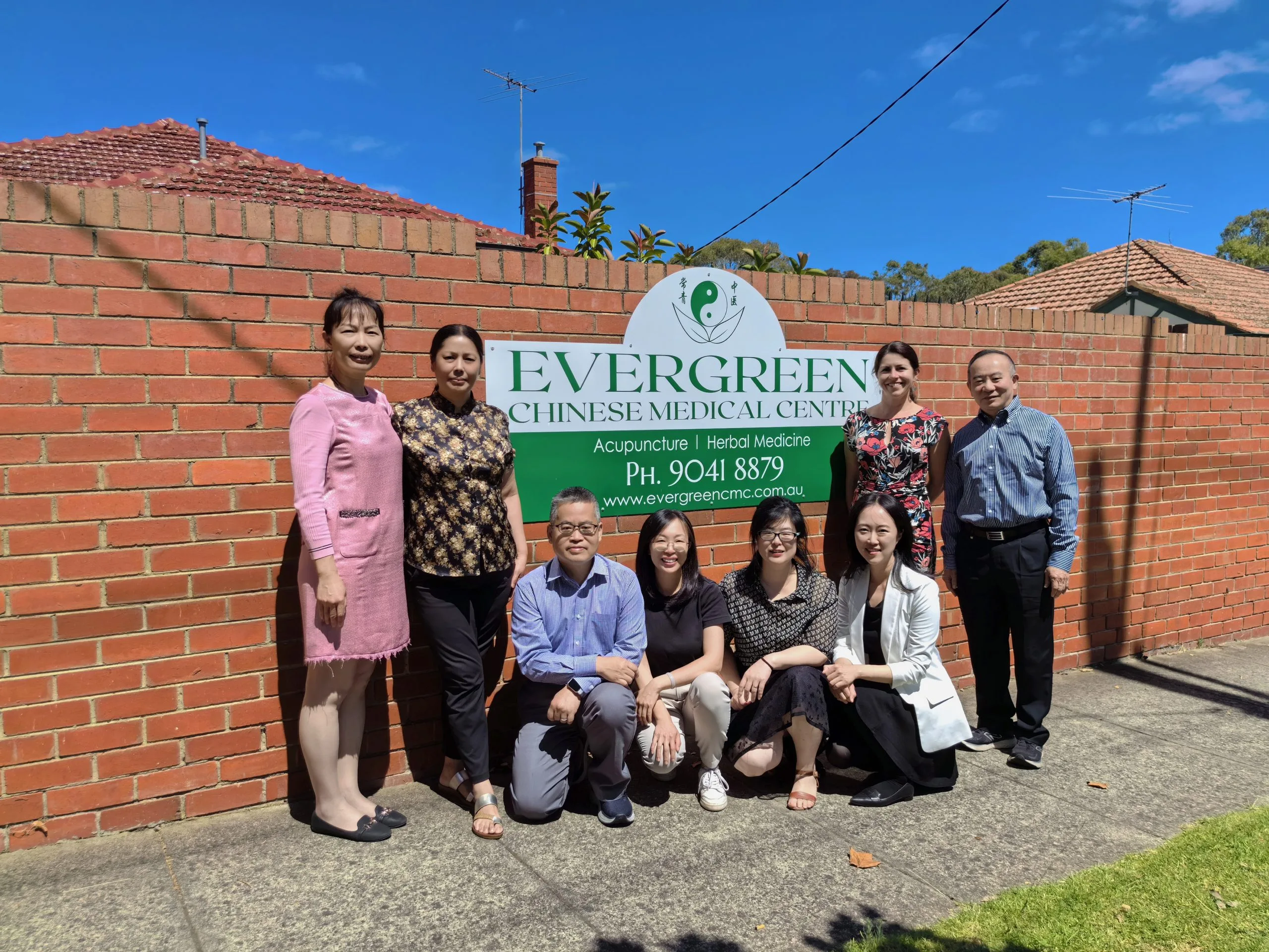 Evergreen practitioners in front of the clinic sign — Acupuncture and Herbal Medicine, Murrumbeena